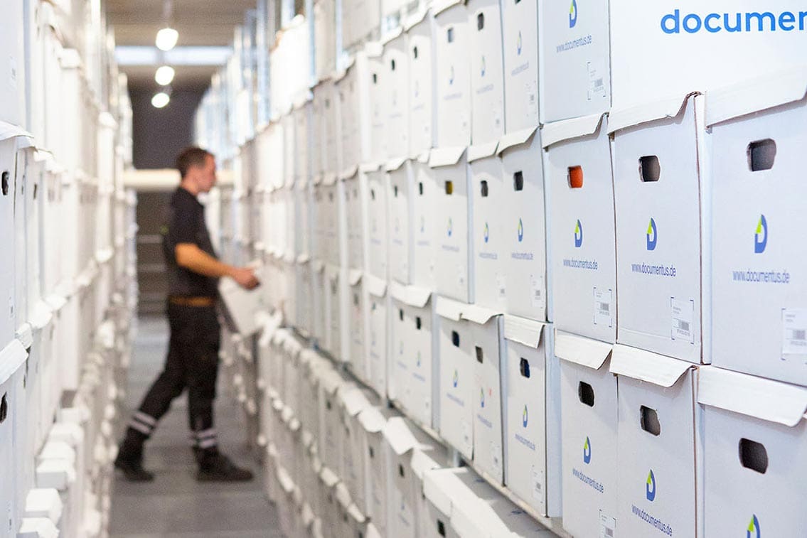 Ein Mitarbeiter sieht im Archiv nach archivierten Akten